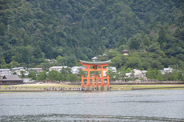 Cổng nổi Torii nhìn từ bến phà Miyajima, nổi lên giữa mặt biển xanh ngọc cùng núi non hùng vĩ bao quanh