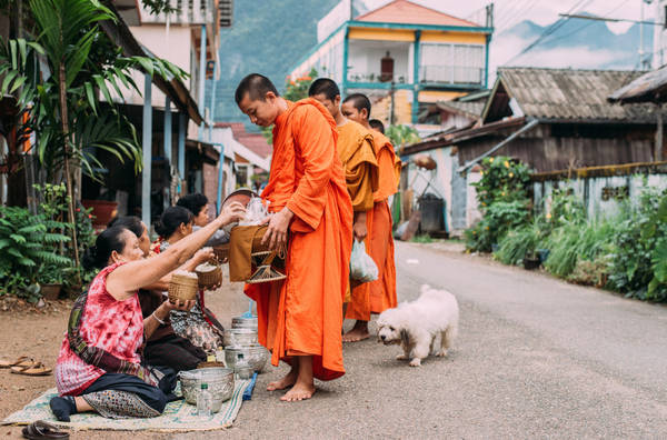 Nhà sư đi khuất thực trên đường phố Vang Vieng. Ảnh: Ahmad Syukaery