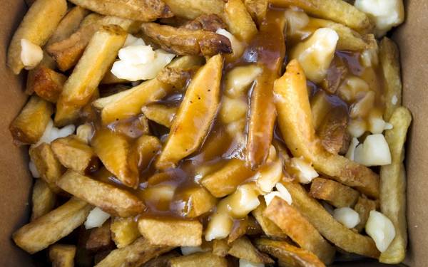 Poutine (Canada): Khoai tây chiên rưới nước thịt và thêm phô mai vừa rẻ, vừa ngon. Đây là món ăn được nhiều du khách yêu thích. Ảnh: Roughguides.