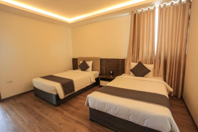 Phòng Deluxe có tone màu trắng tinh khôi cùng nền nhà lát gỗ vô cùng sang trọng. (Nguồn: Booking.com)